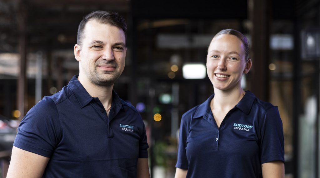 Man and Woman in Navy Blue Suntory Oceania Uniforms